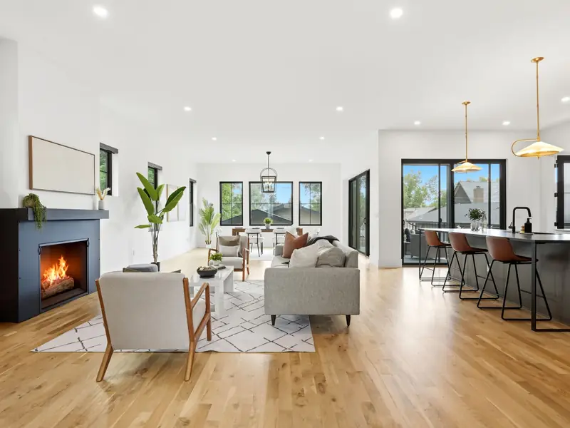 Open living room with a fireplace and kitchen beyond